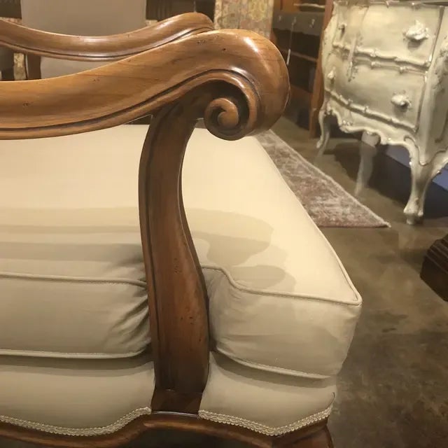 Arm Chair with carved legs, exposed frame back and loose seat cushion upholstered in taupe colored muslin. Created in Italy.