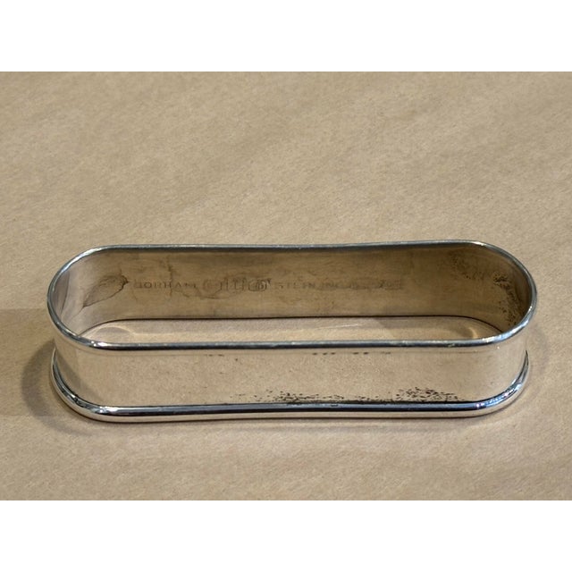 This is an antique Gorham sterling silver napkin ring. It has an initial engraving. It is a unique shape and very stunning.