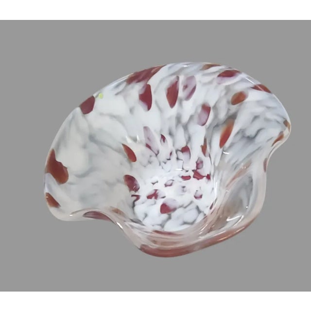 Add a touch of vintage charm to your home decor with this beautiful hand-blown glass bowl. The intricate abstract shape...