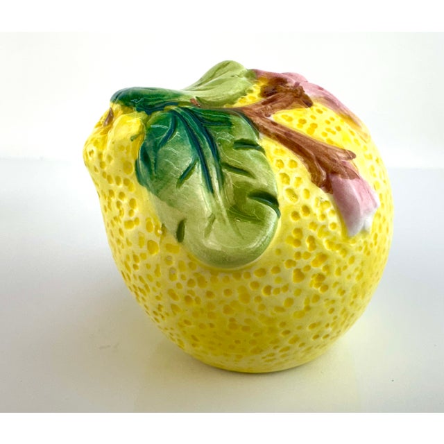 A detailed pair of vintage majolica-style salt and pepper shakers formed as ripe lemons, glazed in saturated yellow with...