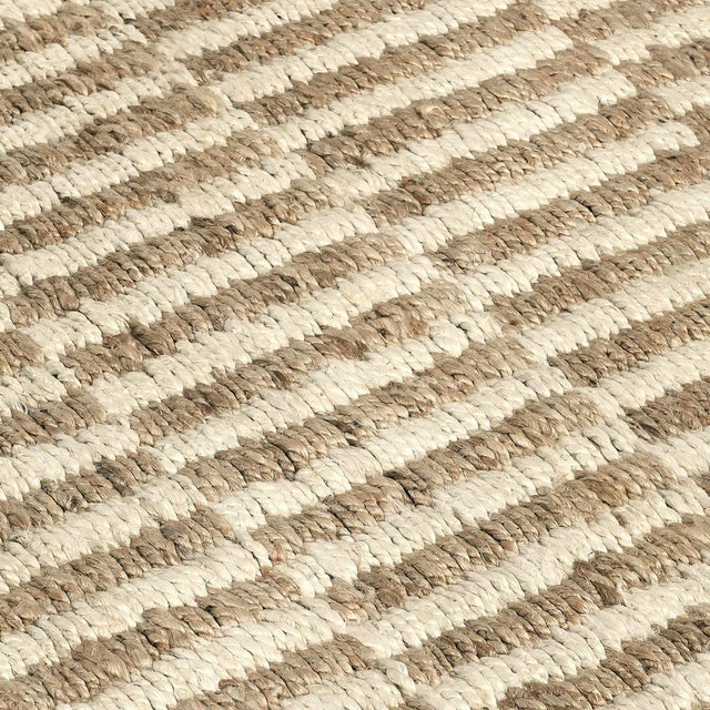Hand woven jute rug in natural and ivory tones. Alternating color pattern creates a rhythmic tile-like effect. Please note...