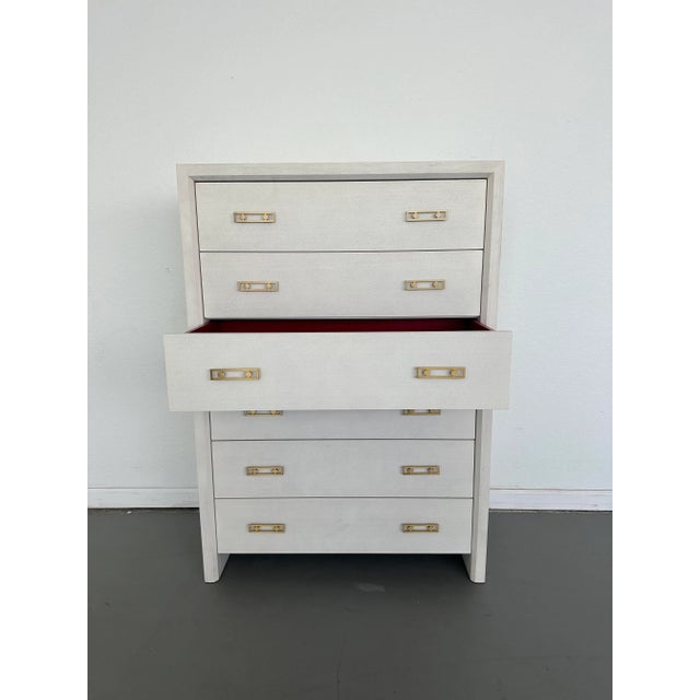 Soft matte-white painted finish on rich, open-grain mahogany Six drawers Signature red lacquer interior in drawers Open-...