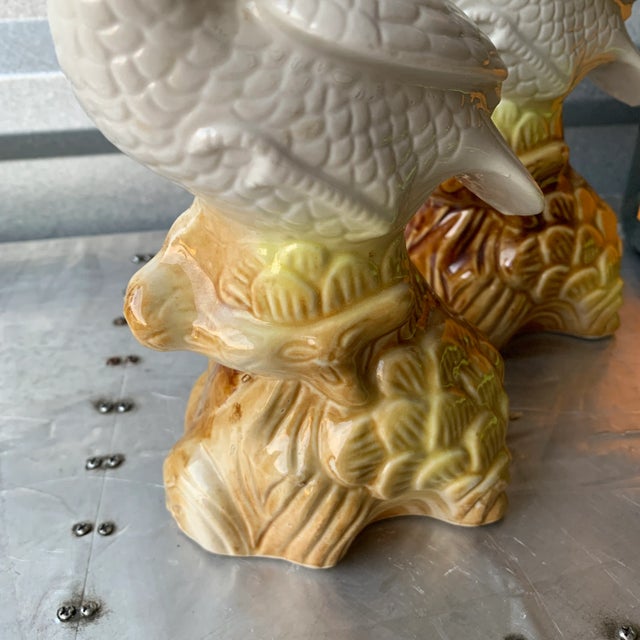 A pair of figurines that would look great on a bookshelf. White with touches of yellow and then brown on their perches.