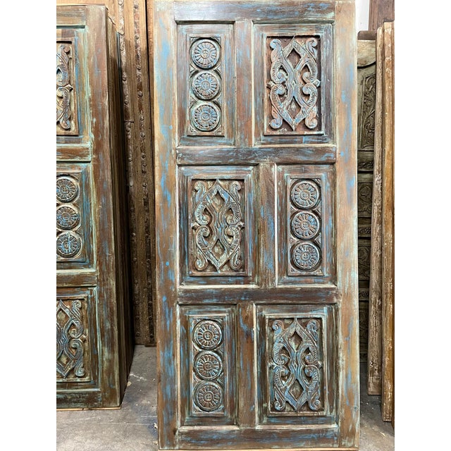 A beautifully aged sliding barn door featuring hand-carved lotus and floral detailing across its face. Finished in a...