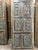 A beautifully aged sliding barn door featuring hand-carved lotus and floral detailing across its face. Finished in a...