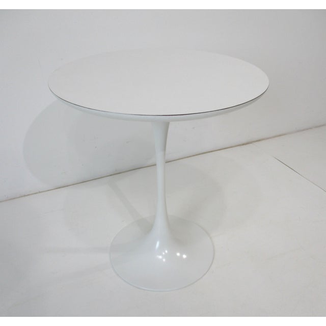 A very elegant Midcentury white tulip side table with heavy metal base and white laminate top making the piece very...