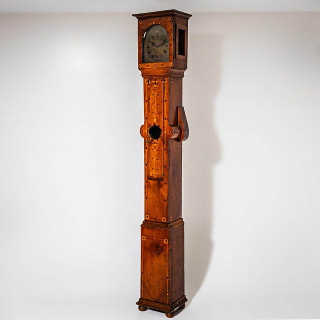 Large cherrywood grandfather clock raised on ball feet and decorated with framed marquetry inlays. The clock case features...