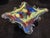 This is an organic, multi-pointed Murano style art glass bowl featuring a splash of vibrant colors encased in clear glass....