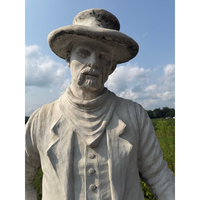 A monumental hand-cast concrete sculpture of a Western gunslinger, standing 80 inches tall. This is a heavy, solid piece,...
