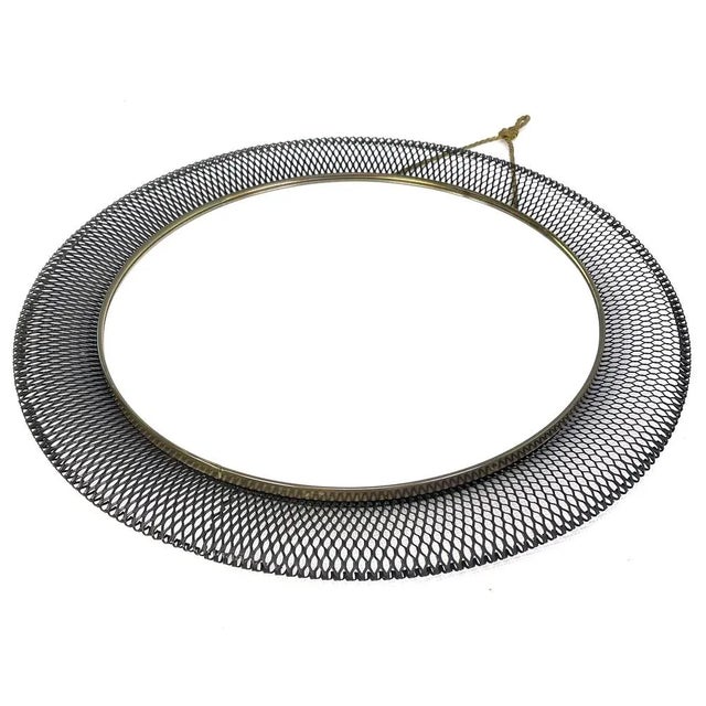 This vintage wall mirror is an original from the 50s. It is in terms of time.