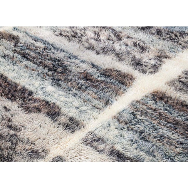 A patchwork of tone, texture, and quiet complexity. This rug reveals itself as a layered composition of irregular color-...