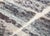 A patchwork of tone, texture, and quiet complexity. This rug reveals itself as a layered composition of irregular color-...