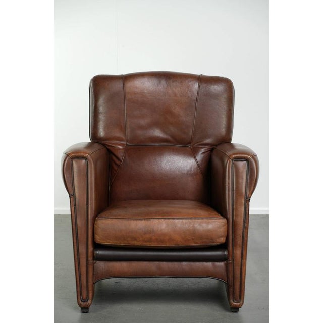 This Art Nouveau-style sheepskin armchair is crafted in a dark brown color. The armchair features a removable seat...