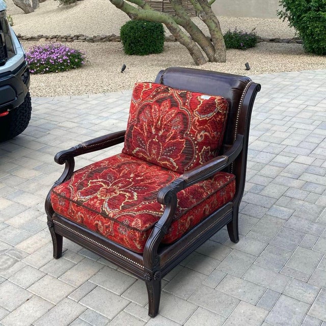 This Paul Schatz lounge chair features a sturdy dark wood frame and comfortable cushions with a rich red floral pattern....