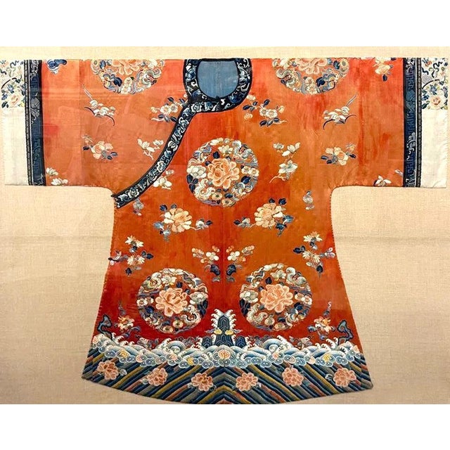 A woman's court coat made from fine orange color silk with wide sleeves from Chinese Qing Dynasty (mid 19th century),...