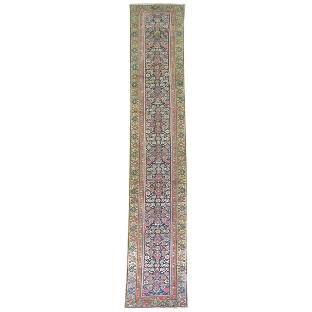 An authentic early 20th century long Persian Ferehan runner sporting a classic herati motif on a navy field. Measures:...