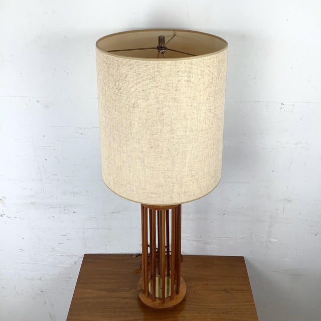 This vintage table lamp features a sculptural mid-century form defined by an open column of rounded walnut dowels. The...