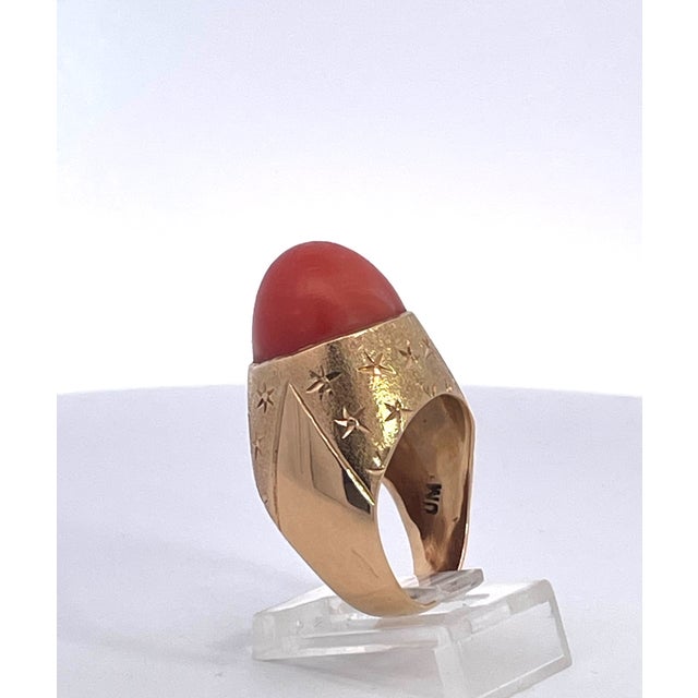 This impressive vintage cocktail ring showcases a large oval cabochon of rich Mediterranean coral, its deep warm orange...