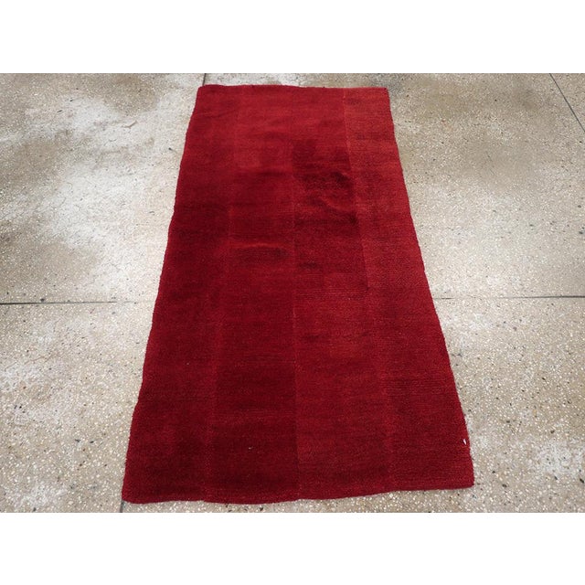 A wool pile of Tibetan knots on a cotton foundation. This is a four-section red monochrome scatter. The reds are subtly...