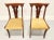 A pair of dining side chairs in the Empire style, unbranded. Solid cherry with carved bar back crest rail, carved...