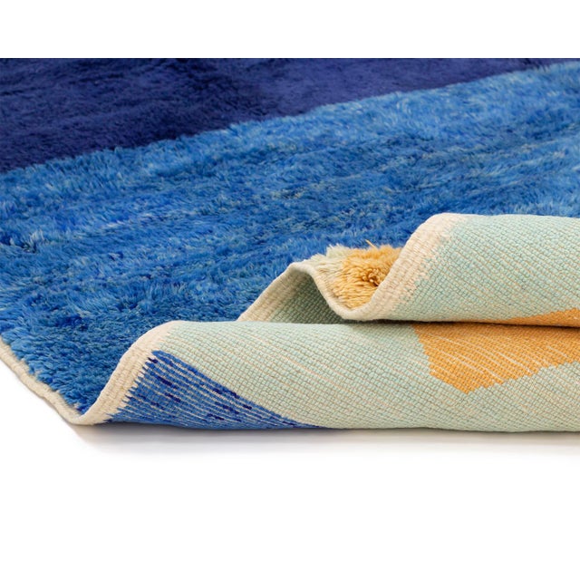 Sea, sky, and a single sun: a modern horizon, drawn in bold bands of color. Three wide horizontal fields divide the rug...