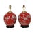 The lamps feature a classic ginger jar shape and are adorned with a vibrant, rich coral red. The ceramic bodies are hand-...