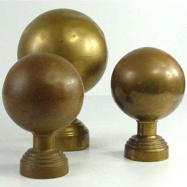 A set of decorative spheres made of relatively thick, gold-colored sheet metal (brass or brass-plated). They are likely...