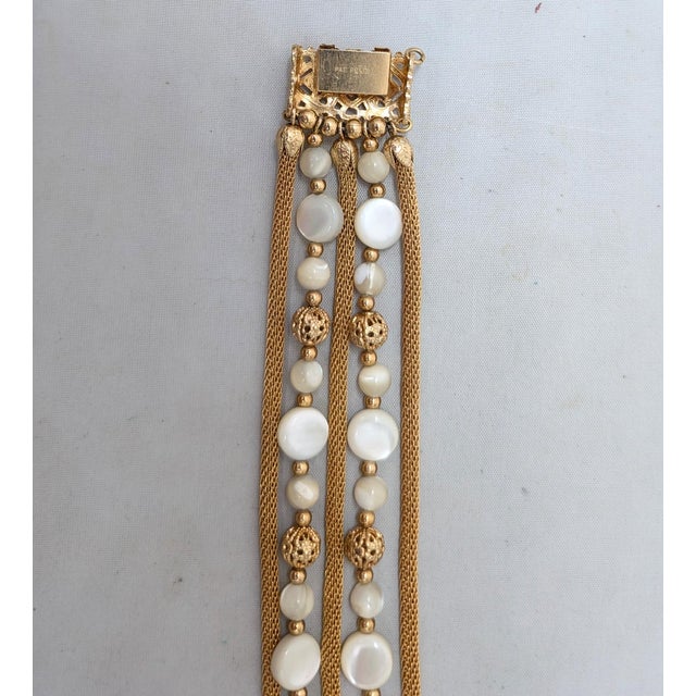 1960s goldtone 5-strand with 3 mesh strands and 2 strands of spherical and round flat mother-of-pearl beads with filigree...