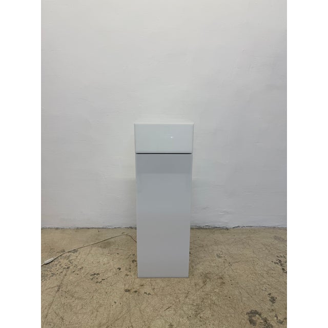 Rotating turntable top white Lucite pedestal table by Haziza. The top rotates via internal motor when switched on.