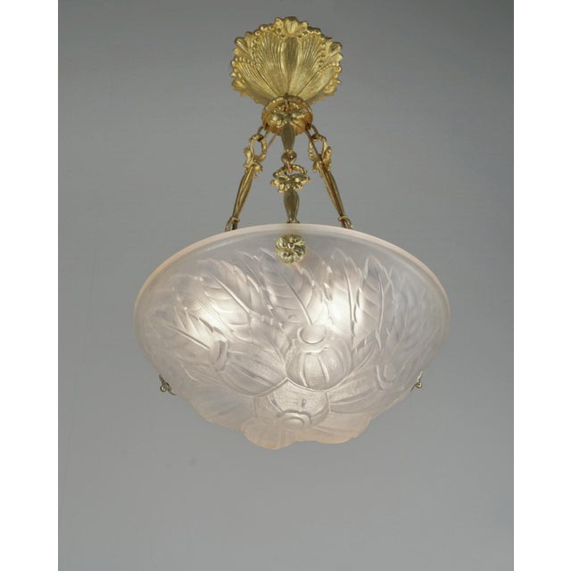 Verrerie des Vosges A French 1925-1930 art deco chandelier in gilded solid bronze holding a beautiful bowl in frosted...