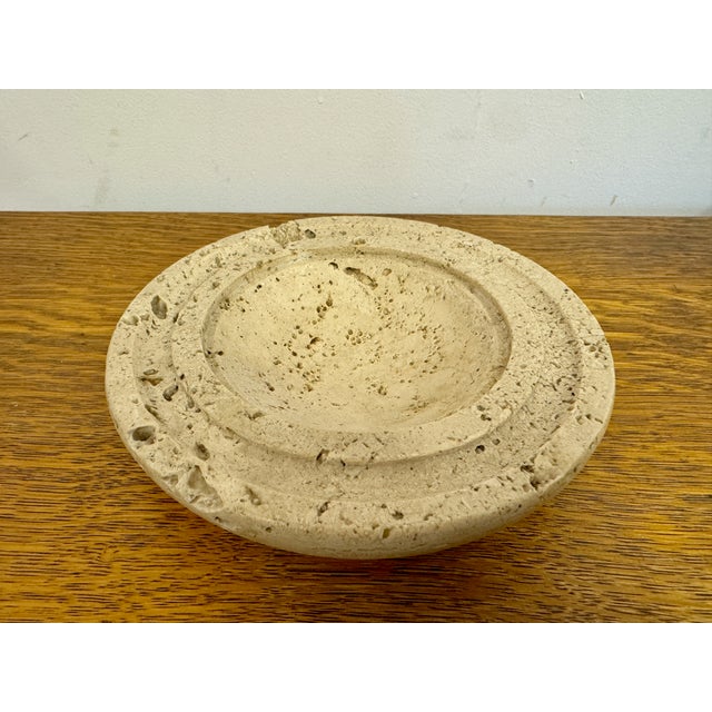 A round travertine bowl, dating from the 1970s, exemplifies the elegant and natural aesthetic typical of that era's...
