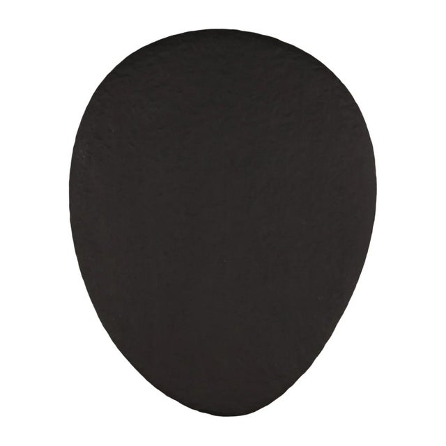 Hand chiseled wood three-leg coffee table with handsome black finish. Unique egg shaped top. Modern mixed with a primitive...