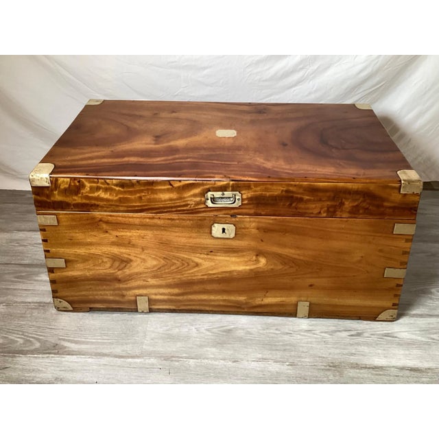 A mid-19th century English camphor wood campaign chest. The chest with brass braces and corners with handles on each side....