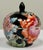 Petite vintage Asian chinoiserie lidded ceramic ginger jar adorned with a black enamel base and pinks, rust, gold and...