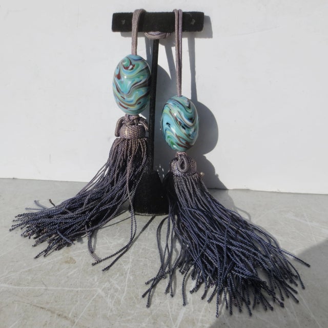 Vintage Chinese glass scroll weights with soft faded tassels. Silvered faded denim blue colors. The glass is a swirl of...