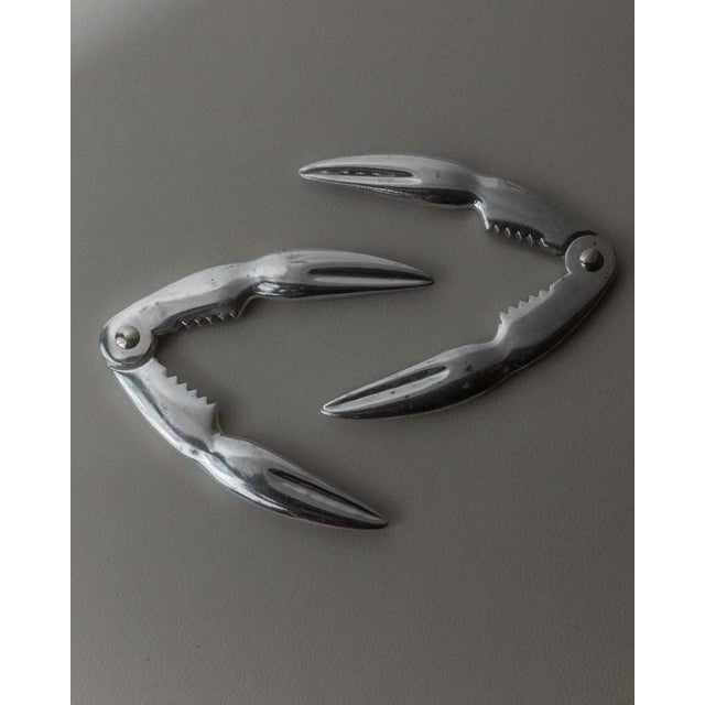 This vintage set of 2 silver-plated lobster crackers from the 1960s features an elegant crab claw shape design that...