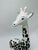 This ceramic giraffe has a charming, whimsical style. It’s depicted in a seated position with its legs tucked under its...