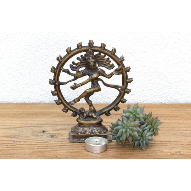 A masterfully cast mid-scale devotional sculpture capturing a stylized sacred figure, boasting a radiant, sun-warmed aged...