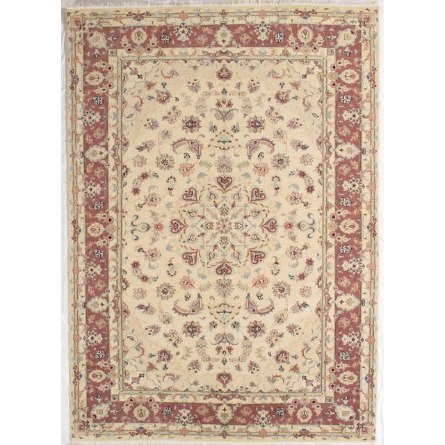 Vintage Hand-knotted Tabriz rug featuring a refined ivory field centered by an intricate floral medallion, surrounded by...