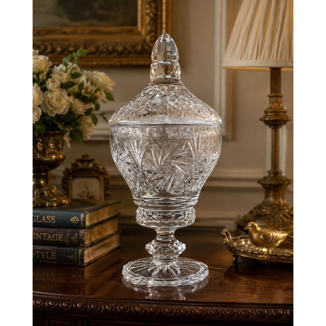 An elegant vintage cut crystal covered apothecary jar featuring intricate starburst and pinwheel-style cuts throughout the...