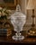 An elegant vintage cut crystal covered apothecary jar featuring intricate starburst and pinwheel-style cuts throughout the...