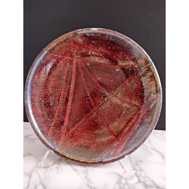 An exquisite 10.5-inch hand-thrown studio pottery charger/plate by artist Nora, dating to the 1970s American studio craft...