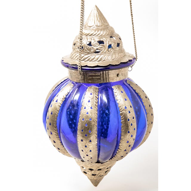 Offering this Moroccan lantern made of pewter with openwork detail. A cobalt blue glass makes the pewter stand out. This...
