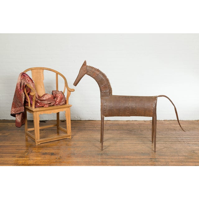 An Indian archaic style vintage cast iron horse sculpture from the mid 20th century. Created in India during the...