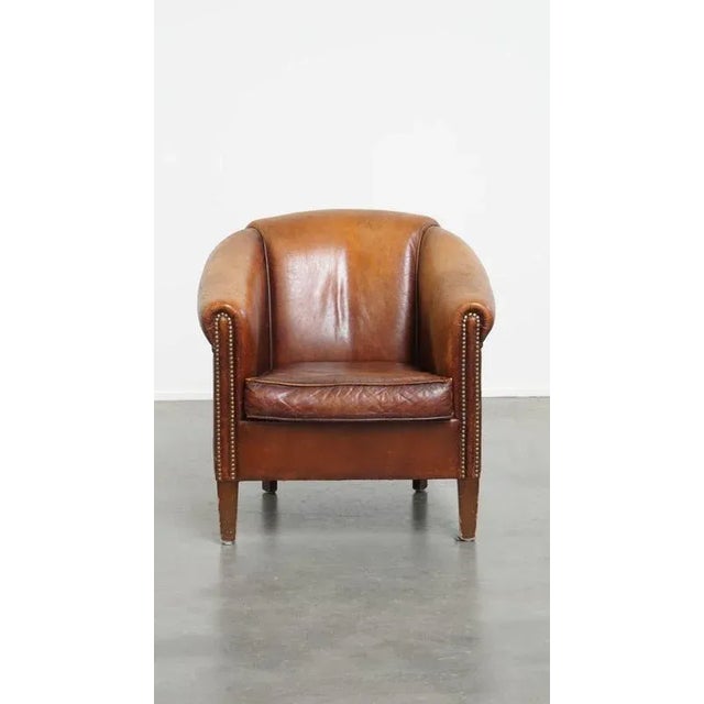 Offered this tough, timeless, cognac colored sheep leather club chair with an insane vintage look. This amazing sheep...