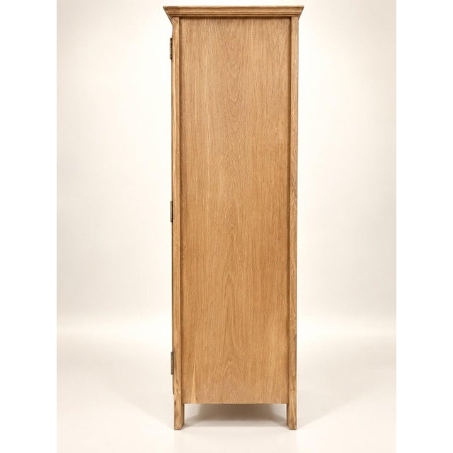 A two-door wardrobe in solid oak, in a classic french provincial style, completely stripped using sandblasting, revealing...