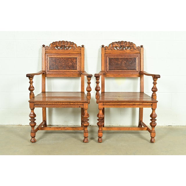 An exceptional pair of antique English Jacobean style armchairs or dining captain chairs By Batesville Cabinet Co. (early...