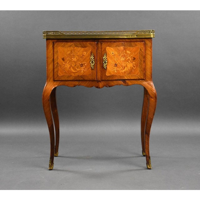 A good quality antique French marquetry side cabinet, of bowed form, with a three quarter pierced brass gallery, having a...