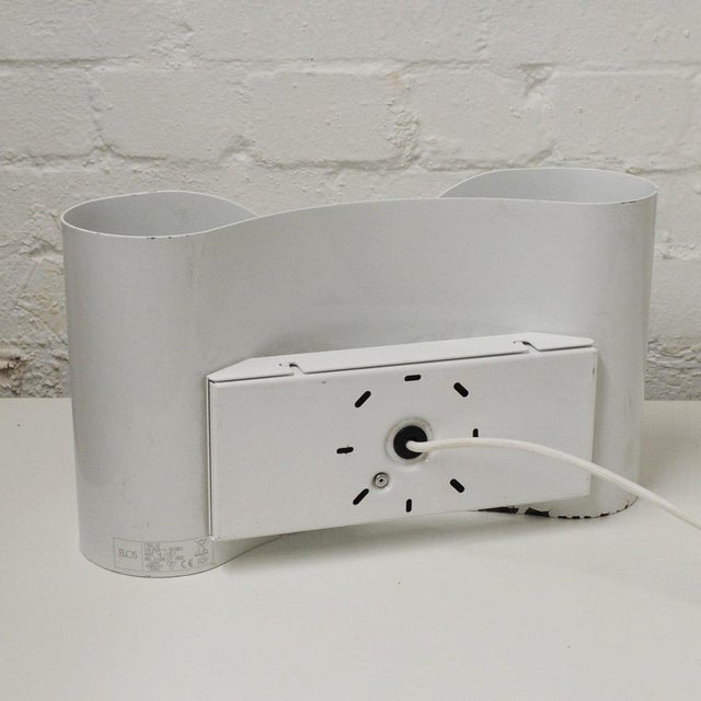 A vintage pair of metal wall lamps from the 1980s by Flos. This piece is attributed to the mentioned designer/maker. It...