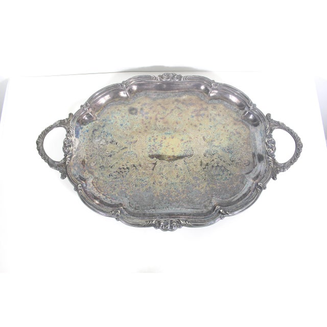 Large vintage silver plated footed tray with gorgeous ornate scalloped detail around the edge and handles and an embossed...